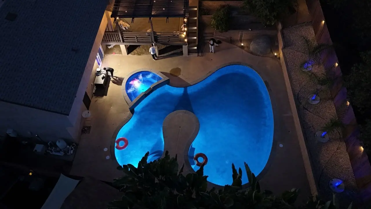 Finished freeform pool and spa lit at night after remodel in Escondido, CA