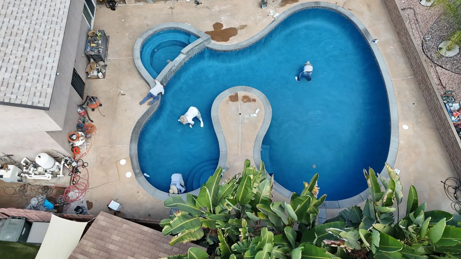 Crew applying final finish to figure-8 pool remodel in Escondido