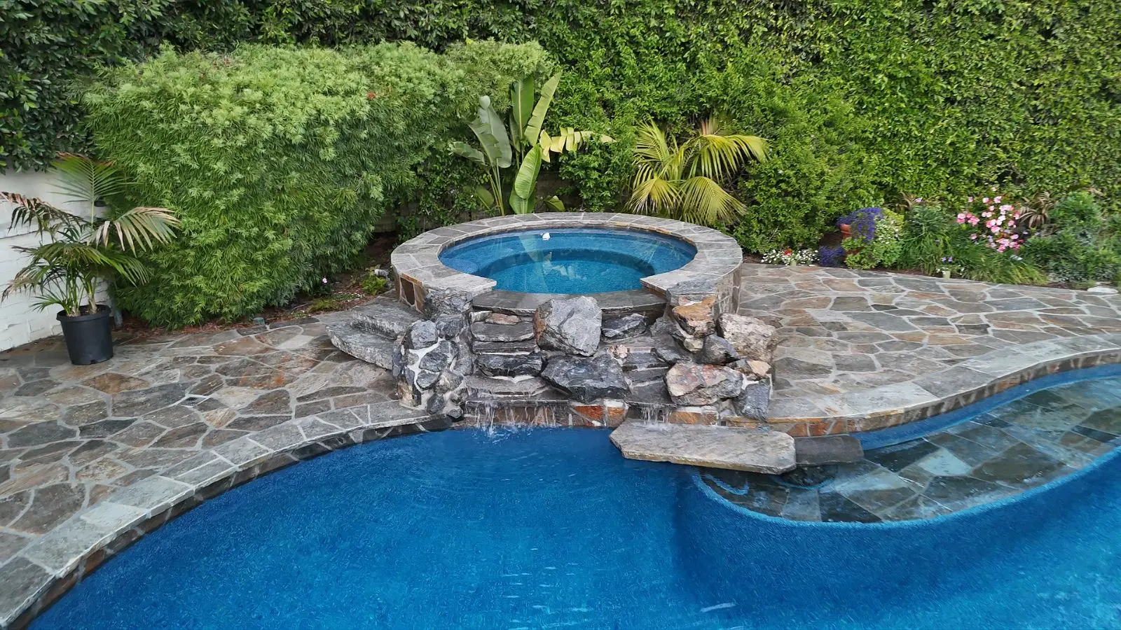 Round raised spa with rock waterfall into freeform pool, Escondido
