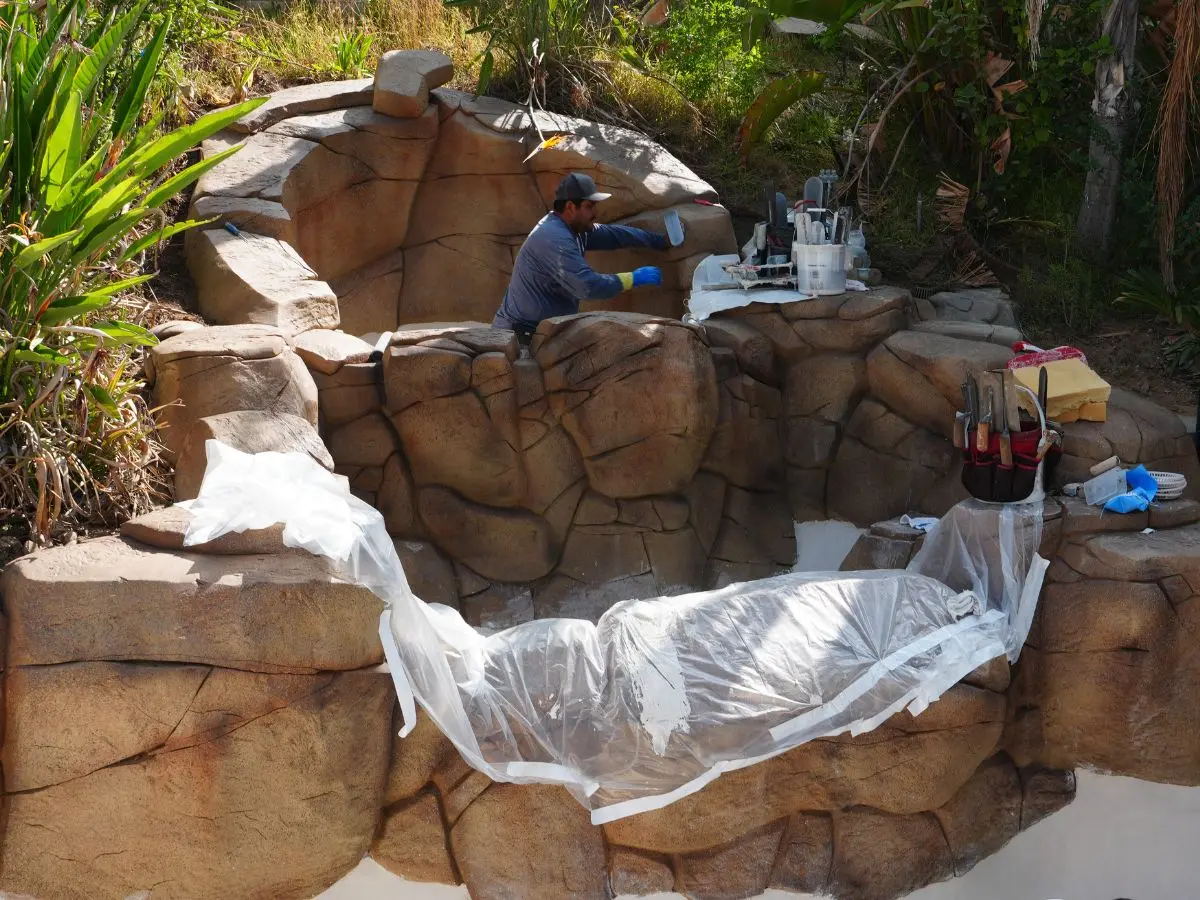 Aguas Pools crew hand-troweling a natural rock waterfall feature